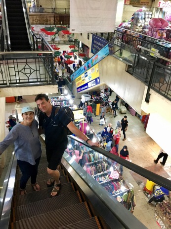 Going up an escalator in Pasar Baru